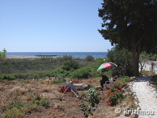 Ein Sonnenschirm wird die Köpfe der sich abwechselnden Spießdreher vor